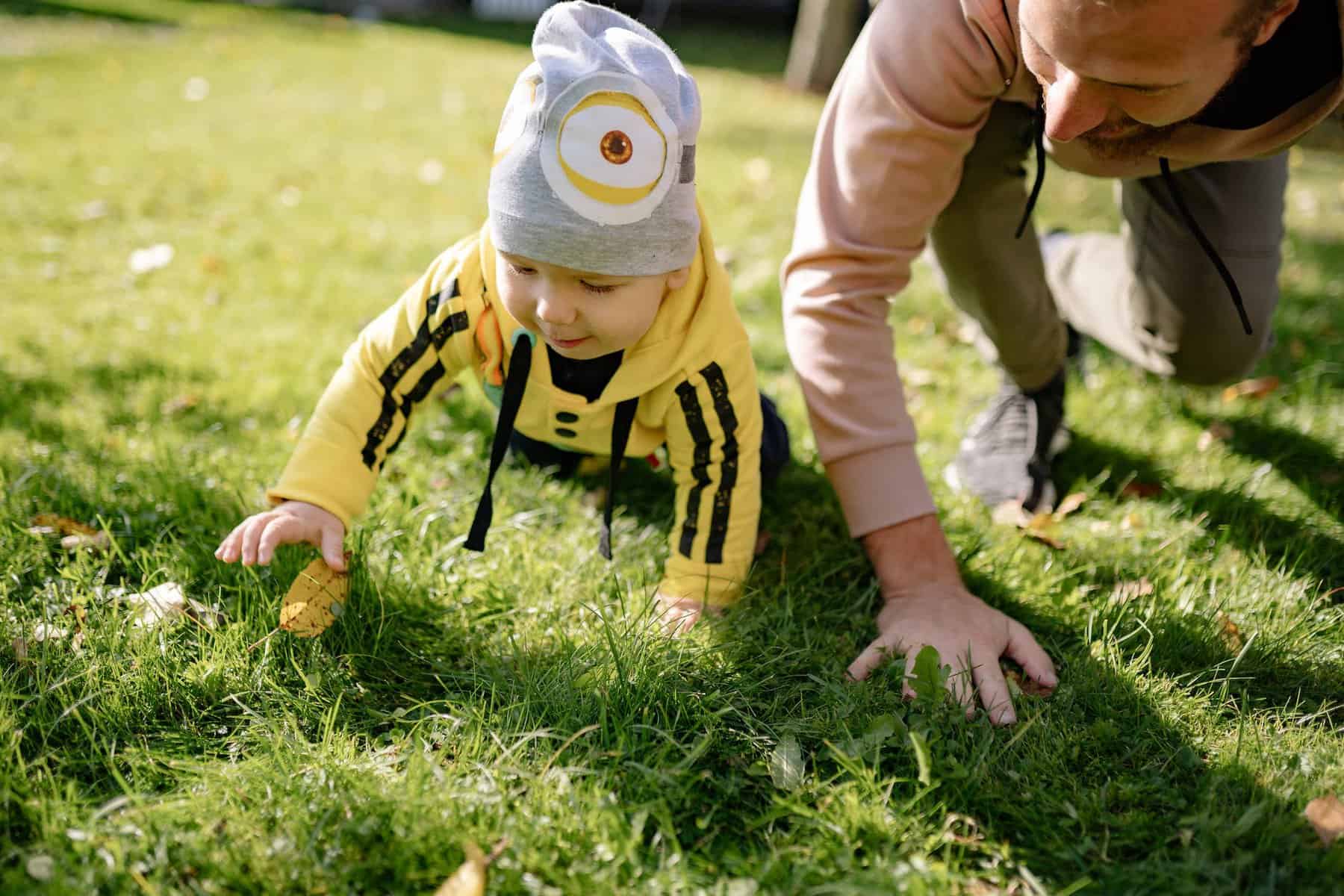 a kid crawling on the grass