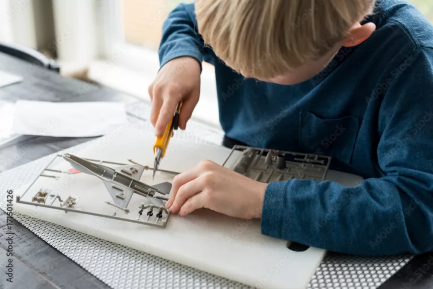 Little boy building model airplane educational hobby