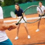 Group of healthy happy friends at the club playing tennis
